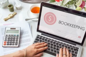 laptop with bookkeeping on the screen in pink