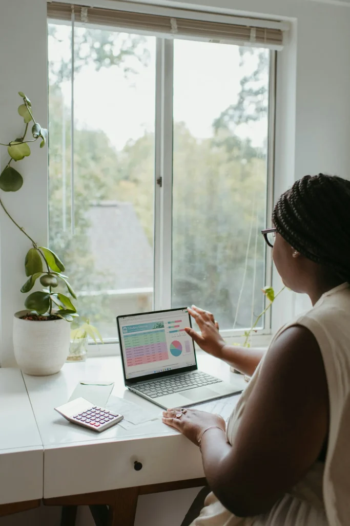 Bookkeeper looking at spreadsheet with dashboard on laptop screen compressed