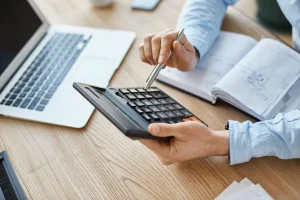 Manager holding calculator checking profits compressed
